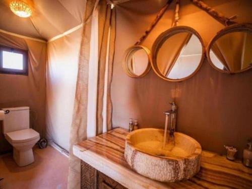 a bathroom with a wooden sink and mirrors at Stellar Luxury Camp in Merzouga