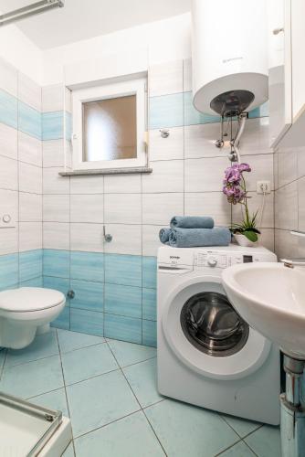 a bathroom with a washing machine and a sink at Apartments Manuela in Pula
