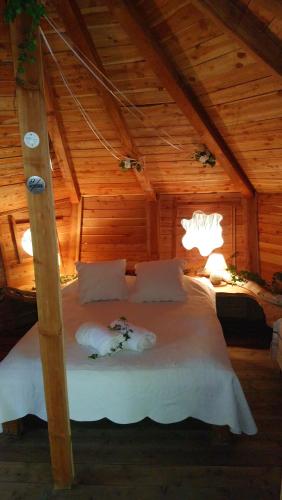 a bedroom with a white bed in a attic at Les Maisons De Chante Oiseau, Maisons, Lodges, Tentes et Cabane in Sigonce