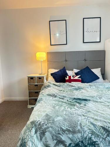 a bedroom with a large bed with blue pillows at Aldershot Spacious 3-Bedroom House with Fast Wi-Fi & Free Parking in Aldershot