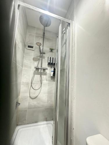 a bathroom with a shower with a glass door at Aldershot Spacious 3-Bedroom House with Fast Wi-Fi & Free Parking in Aldershot