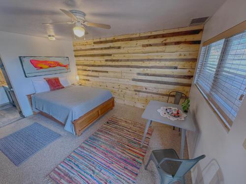 a bedroom with a bed and a wooden wall at Salish Queen Mokee Shared Kitchen Pets OK! #1 in Bluff