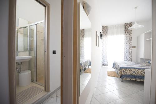 a room with a bathroom with a bed and a mirror at Hotel Gigliola in Bellaria-Igea Marina