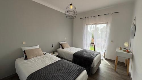 a bedroom with two beds and a window at Monte Rio House in Luz