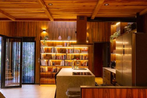 a kitchen with a refrigerator and a book shelf at Chalet urbain-150m2 jardin privatif-15mn de Paris in Le Bourget