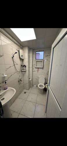 a bathroom with a toilet and a sink and a window at Ozan Konaklama in Hatay