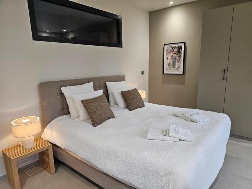 a bedroom with a white bed with a television on the wall at Suite Sieste en Provence in Entrecasteaux