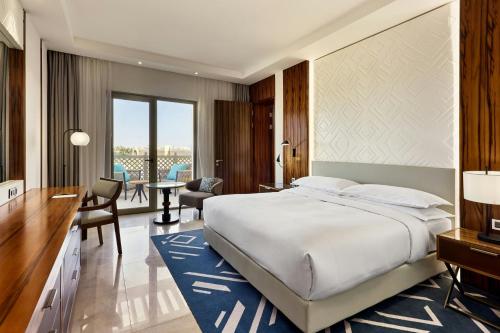 a hotel room with a large bed and a desk at Sheraton Nouakchott Hotel in Nouakchott