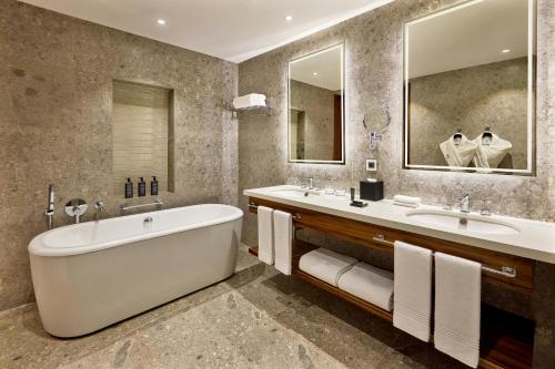 a bathroom with two sinks and a tub and mirrors at Sheraton Nouakchott Hotel in Nouakchott
