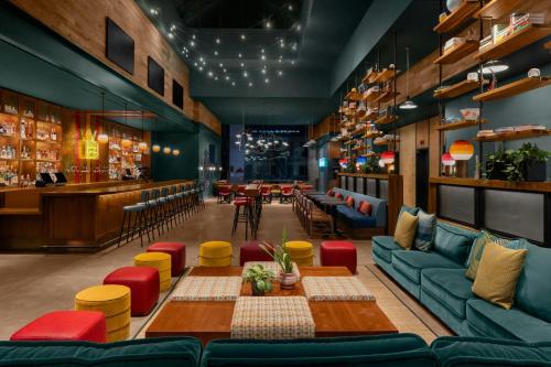 a restaurant with couches and a table and a bar at Moxy NYC Downtown in New York