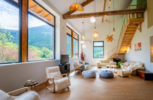 a living room with chairs and a tv and large windows at Retraites & Séminaires, Spa, La Ressource Malix 19 personnes in Tenay