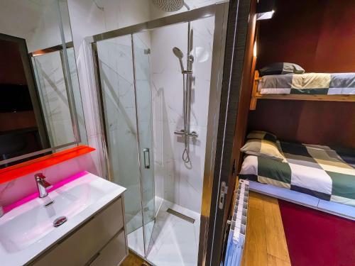 a bathroom with a shower and a sink and a bed at Chalet urbain-150m2 jardin privatif-15mn de Paris in Le Bourget