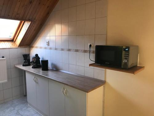 a kitchen with a microwave sitting on a counter at PBJ Apartman in Pilisborosjenő