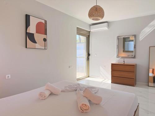a white bedroom with a bed with two towels on it at Cassa Luca in Glarokavmos in Paliouri