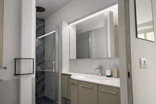 a white bathroom with a sink and a shower at Bilocale in centro a 1 minuto da Piazza Unità in Trieste
