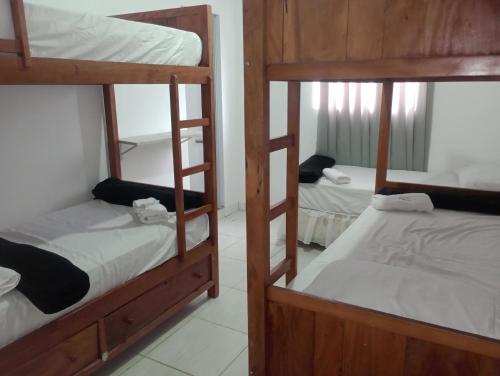 a room with three bunk beds in a room at Pousada e Hostel Campo in Vespasiano
