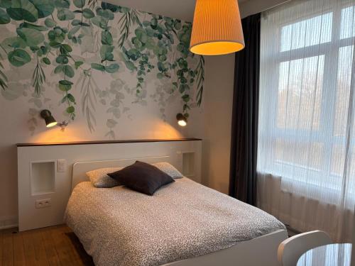 a bedroom with a bed with a pillow on it at La Citadine in Neufchâteau