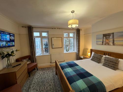 a bedroom with a large bed and a tv at Cosy Budget Rooms in Camden Town near Regents Park in London