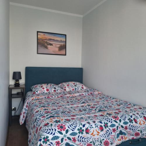 a bedroom with a bed with a colorful comforter at Turkusowa Apartament in Szczecin