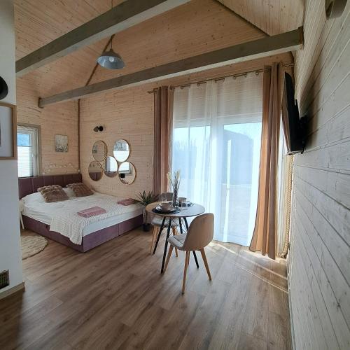 a bedroom with a bed and a table with a chair at Leśny Reset 2 in Grabowo