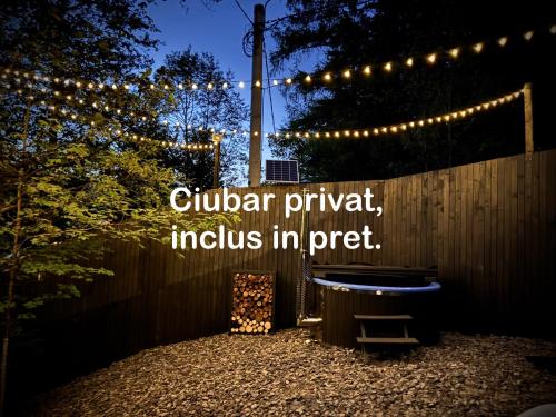 a fence with christmas lights and a bench in a yard at M Cabin A Frame Predeal 2 Ciubar in Predeal
