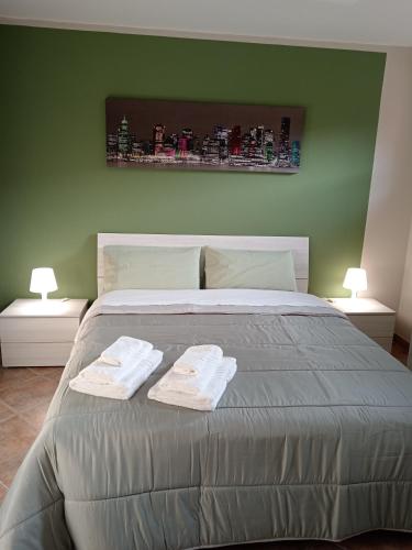 a bedroom with a bed with two towels on it at ATHENA Home Asti in Asti
