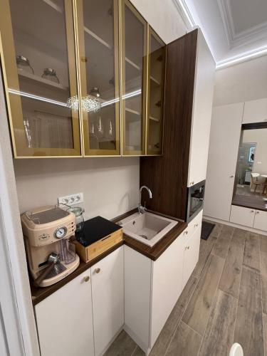 a kitchen with white cabinets and a sink at Apartament Centru Wot Diamond in Arad