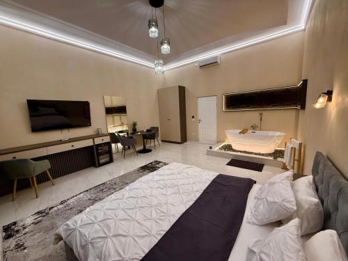a large bedroom with a bed and a tub in it at Apartament Centru Wot Diamond in Arad