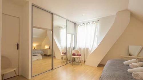 a bedroom with a sliding glass door leading into a room at Villa Coubertin in La Rivière-de-Corps