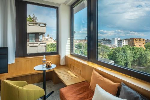 a room with a table and two windows with a view at FirstName Bordeaux, Part of JdV by Hyatt in Bordeaux