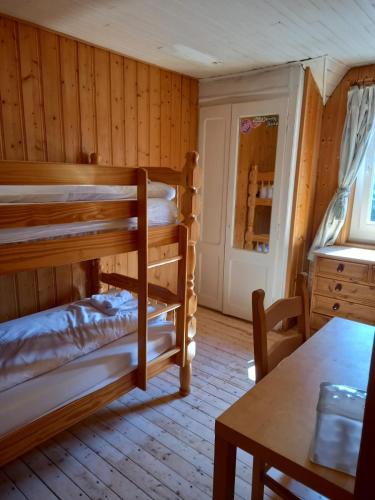 a room with two bunk beds and a table at Nash Apartment in Saint-Jean-d'Aulps