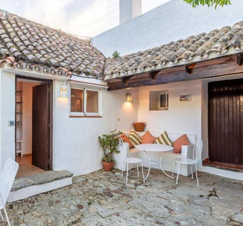 a patio with a table and chairs in front of a house at Hotel-Apart CORTIJO LAS PIÑAS in Tarifa