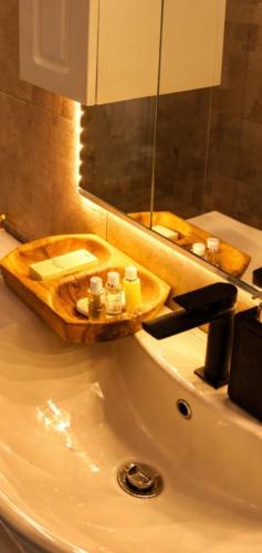 a bathroom sink with a wooden tray with candles on it at Forest Panorama Cabin Brezna in Plužine