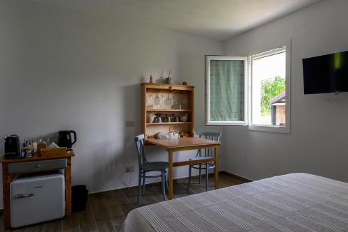 a bedroom with a desk and a table and a window at B&B Lilla All'Adige in Legnago