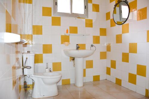 a bathroom with a toilet and a sink at Résidence KEUR FLEURIE in Rufisque
