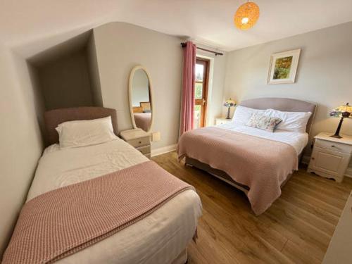 a bedroom with two beds and a mirror at Sea Breeze B&B in Clonakilty