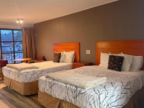 a hotel room with two beds and a window at Mountain House motor Inn Downtown Gatlinburg in Gatlinburg