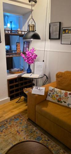 a living room with a couch and a table with flowers at Refúgio no Vale das Furnas - Casa do Sossego in Furnas