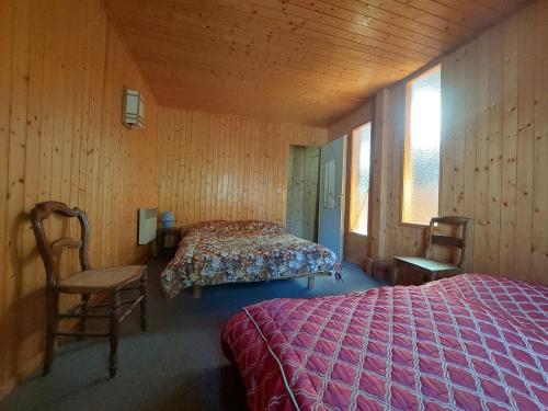 a bedroom with a bed and a chair in a room at La Sauvagine in Les Fourgs