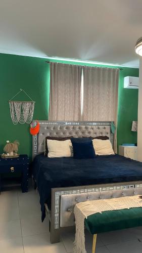 a bedroom with a large bed in a green wall at Simon Vip Complete Villa in Punta Cana