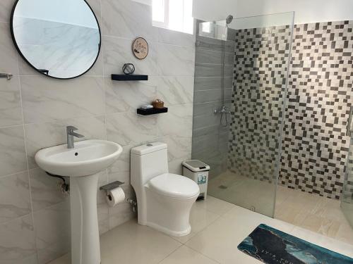 a bathroom with a toilet and a sink and a mirror at Simon Vip Complete Villa in Punta Cana