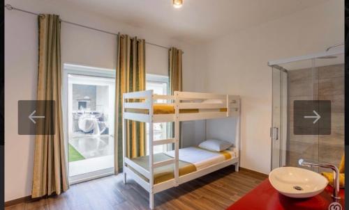 a bedroom with a bunk bed and a bathroom at O Cantinho da Cotovia in Valpaços