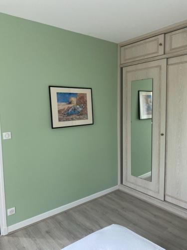 une pièce avec des murs blancs et un miroir dans l'établissement Le Garden, à Néris-les-Bains