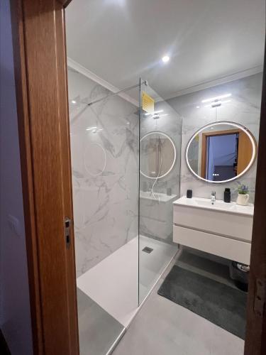 a bathroom with a shower and a sink and a mirror at Atlantic Dream Alto Mar in Garajau