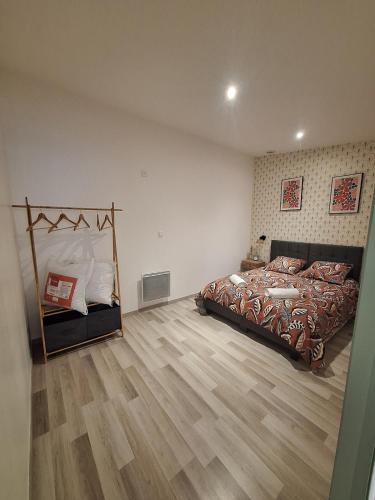 a bedroom with a large bed and a wooden floor at L'escale du Chemin des Dames in Cerny-en-Laonnois