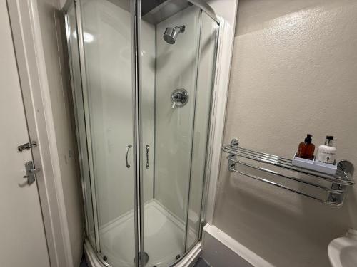 a shower with a glass door in a bathroom at The Old Mill Inn in Bedford