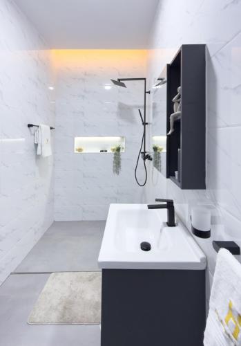 a white bathroom with a sink and a mirror at Serenity Suite in Accra