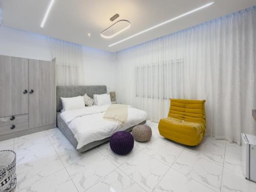 a bedroom with a bed and a yellow chair at Serenity Suite in Accra