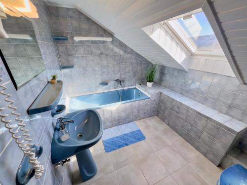 a bathroom with a sink and a bath tub at Fehérló Vendégház & Restaurant in Bük
