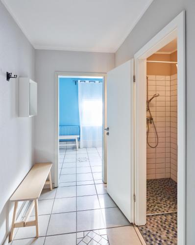 a bathroom with a shower and a tiled floor at Ferienhaus Hängematte für Familien, Freunde und Gruppen in Barth